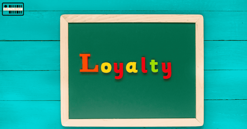 Chalkboard with the word "Loyalty" crafted in colorful, magnetic letters on a teal wooden background, symbolizing the essence of customer loyalty in an engaging digital rewards program.